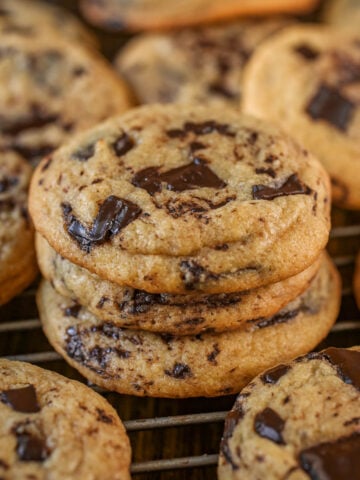 Stack of chocolate chip cookies on a cooling rack.