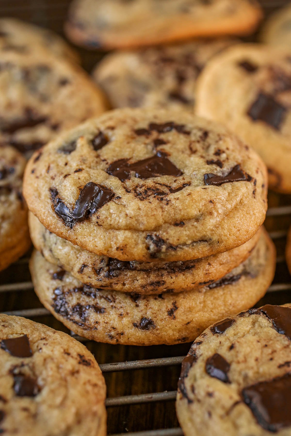 Stack of chocolate chip cookies on a cooling rack.